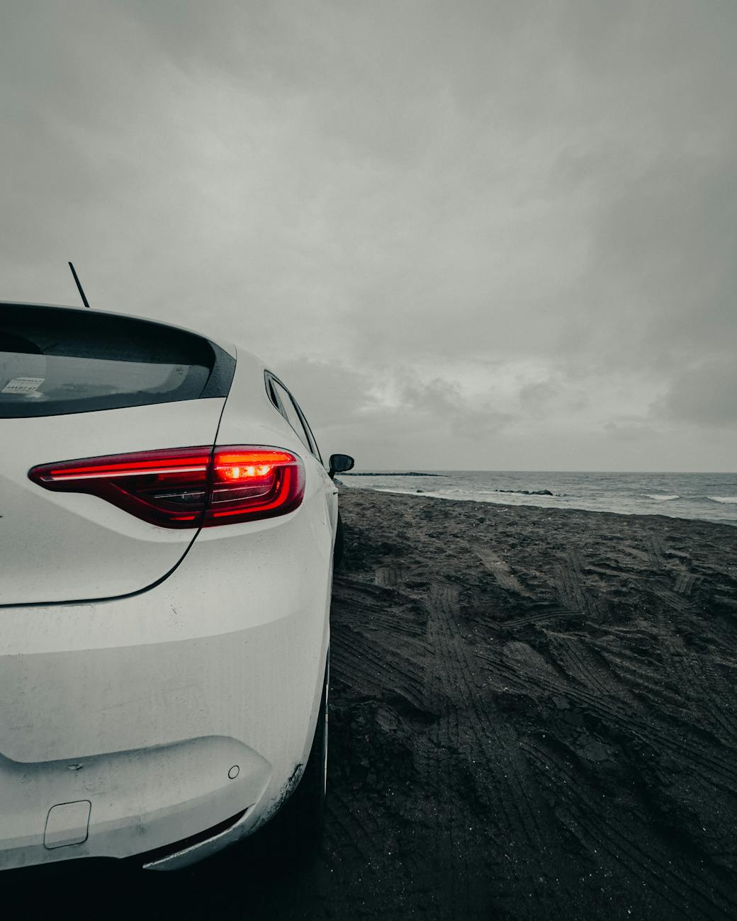white car on the beach at dusk