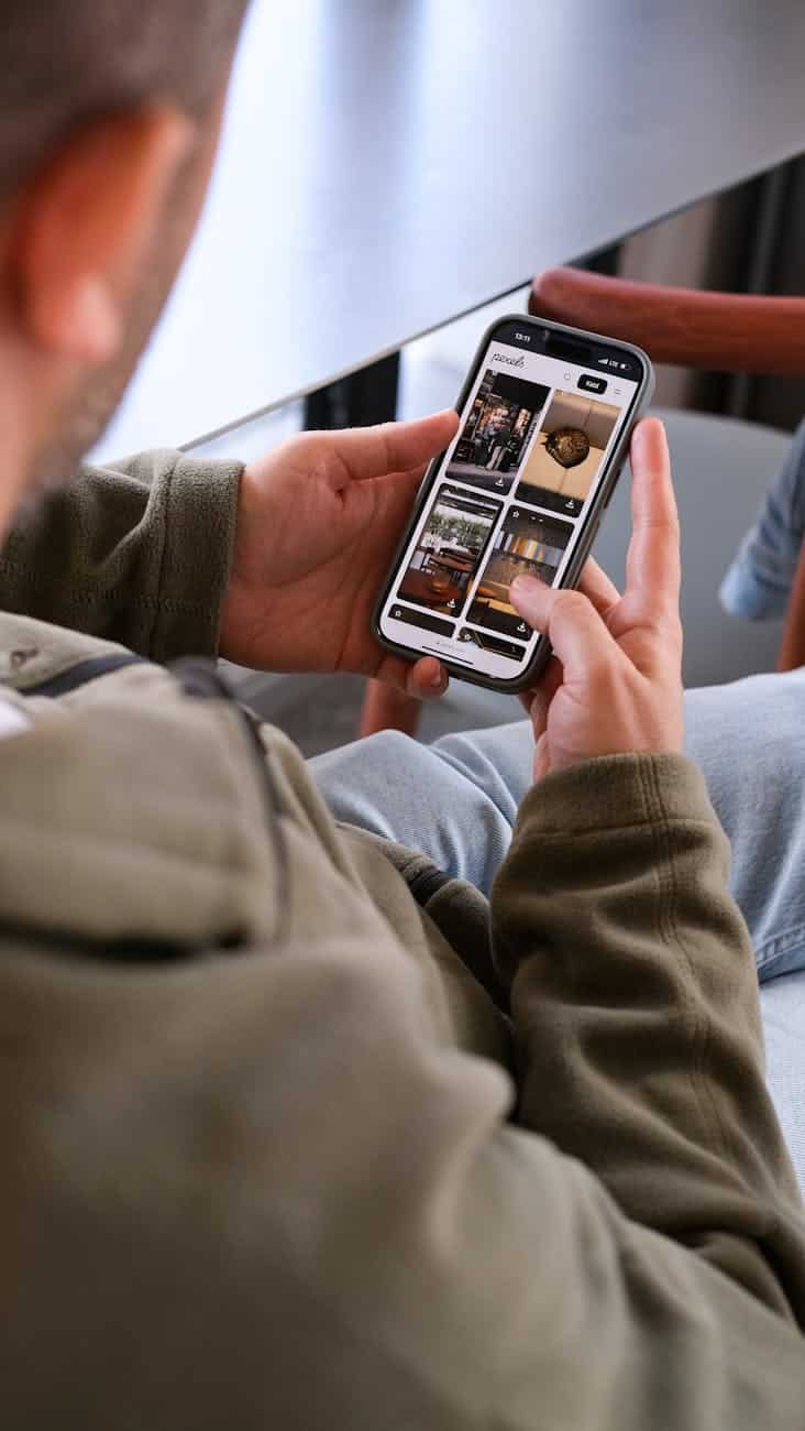 man browsing smartphone while seated indoors