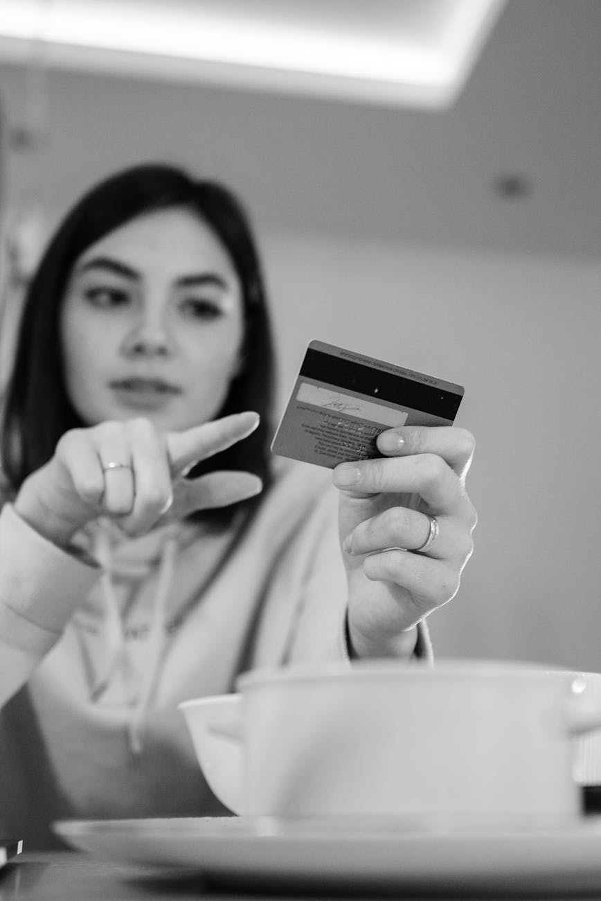 monochrome photo of woman pointing in a debit card